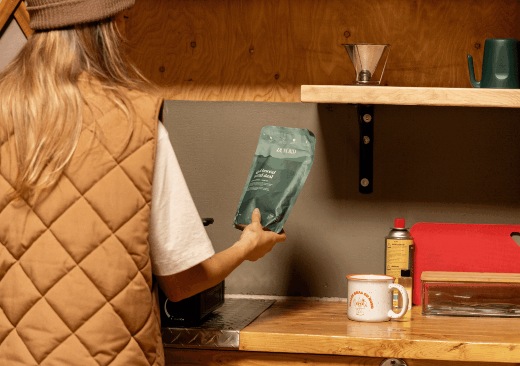 Personne de dos tenant un sac de nourriture prêt à cuisiner en camping