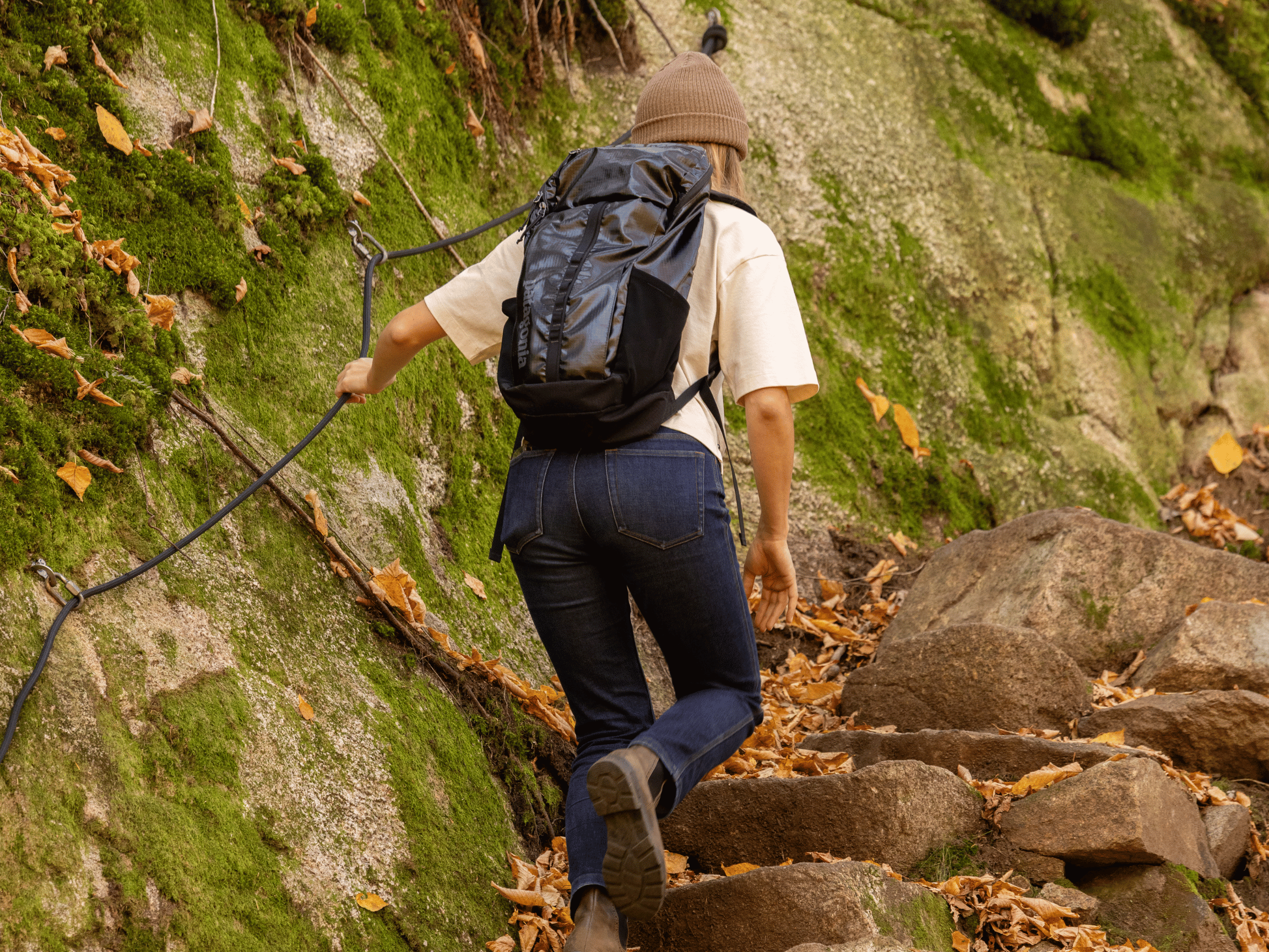 Randonneuse équipée progressant sur un sentier escarpé avec câble de sécurité en forêt, Vallée Bras-du-Nord