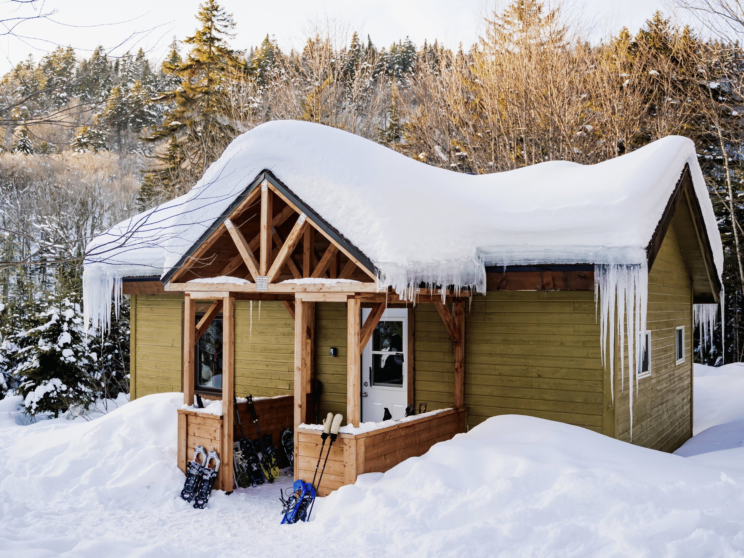 Refuge en bois enneigé au cœur de la forêt à la Vallée Bras-du-Nord, hébergement nature pour la randonnée hivernale.