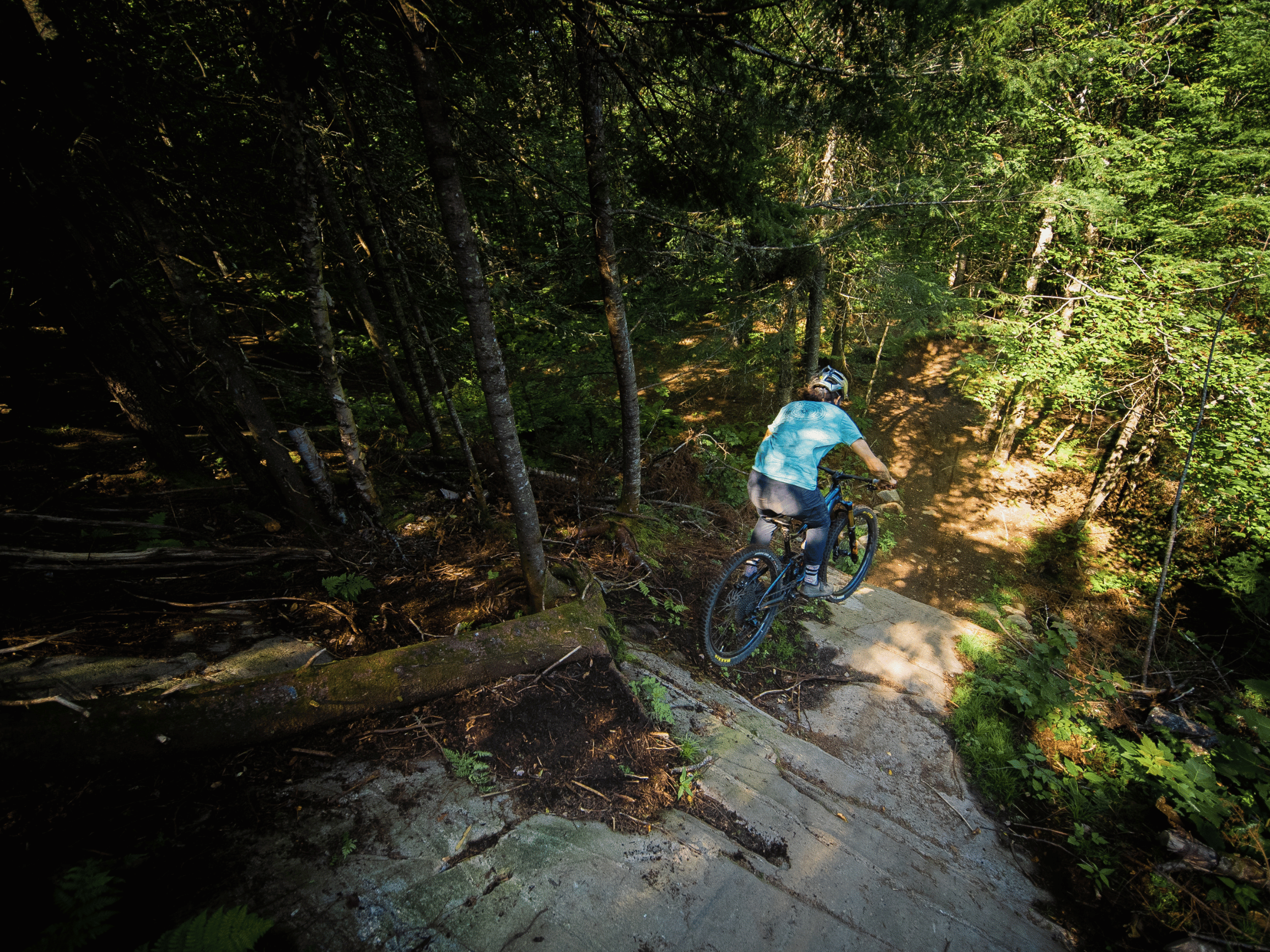 Cycliste sautant une paroi rocheuse à la Vallée Bras-du-Nord.