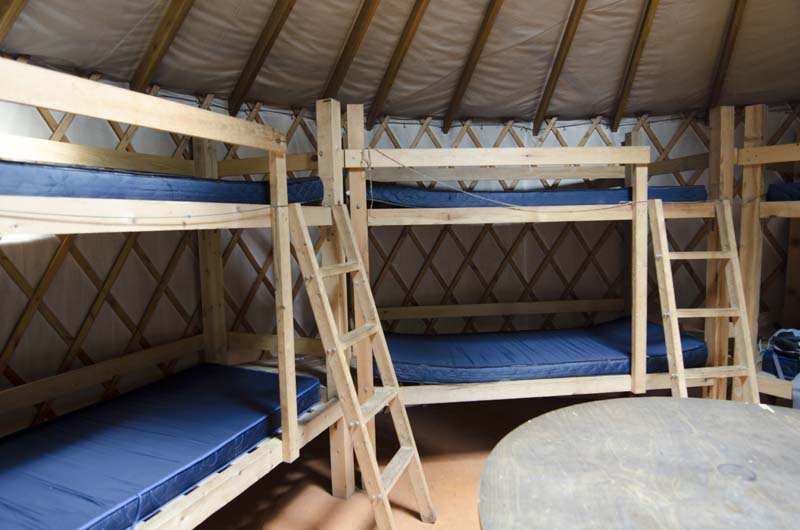 Vue des lits superposés disponibles à l'intérieur de la yourte Delaney, l'un des hébergements offerts dans la gamme des Refuges, en pleine nature à la Vallée.