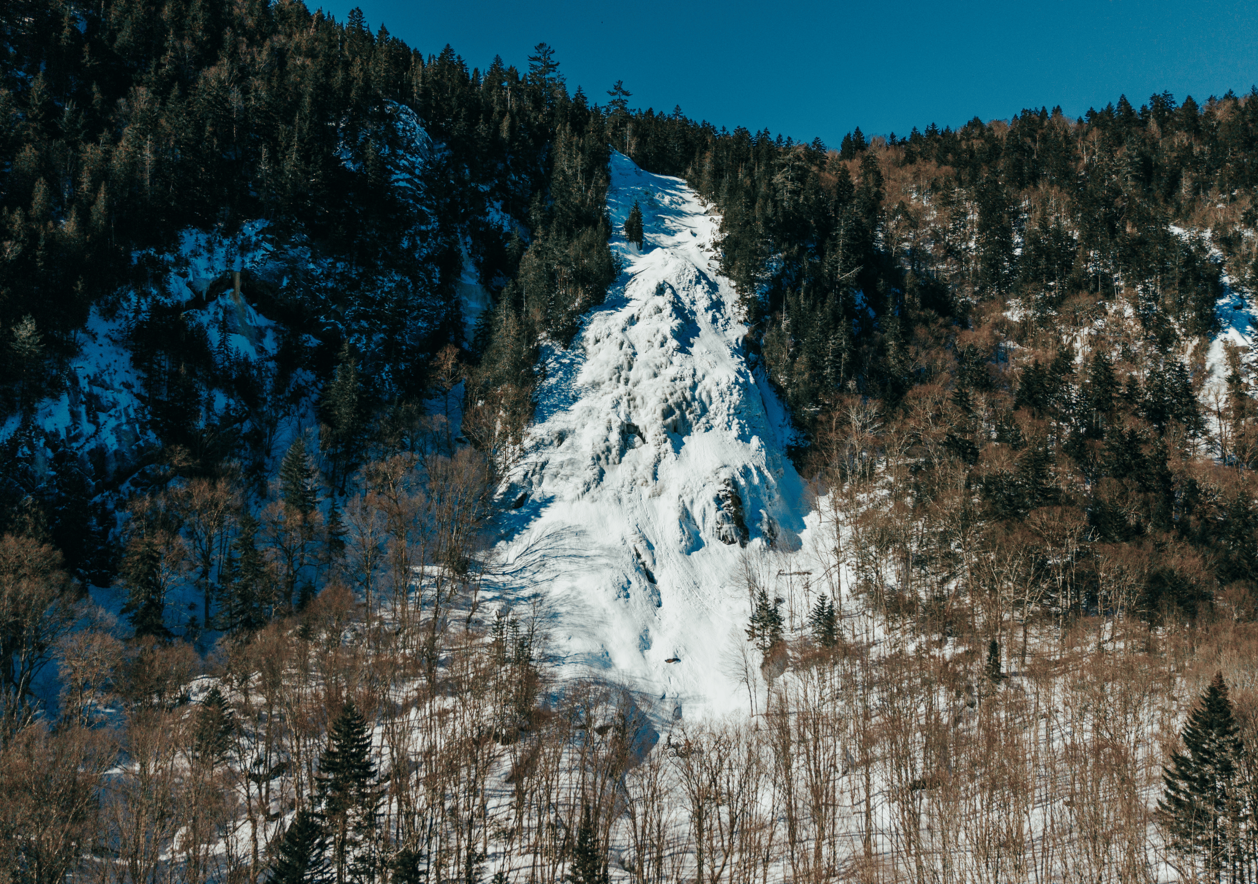 La chute Delaney figée par l’hiver à la Vallée Bras-du-Nord, une randonnée hivernale accessible et spectaculaire pendant le temps des Fêtes.
