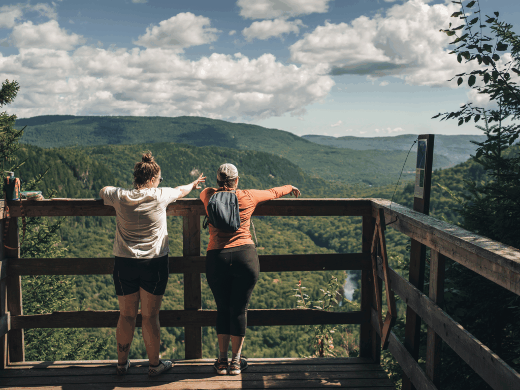 Belvédère avec vue panoramique sur la Vallée Bras-du-Nord à Saint-Raymond, randonneurs admirant les montagnes