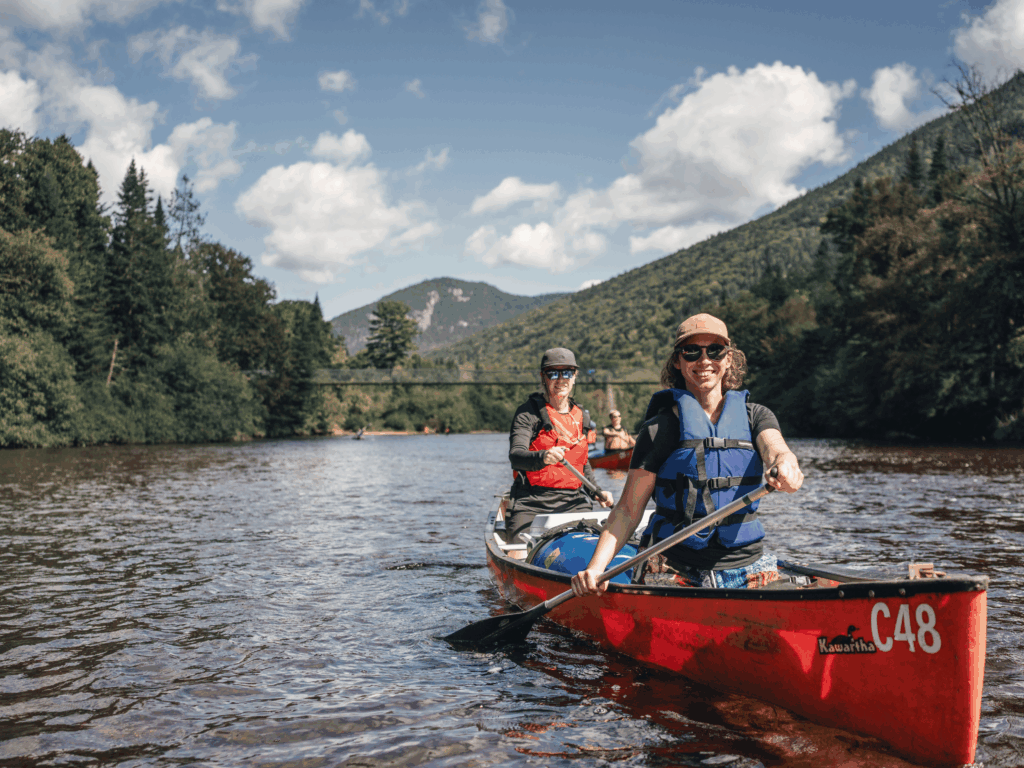 Canot sur la rivière Bras-du-Nord avec vue sur la passerelle et les montagnes environnantes