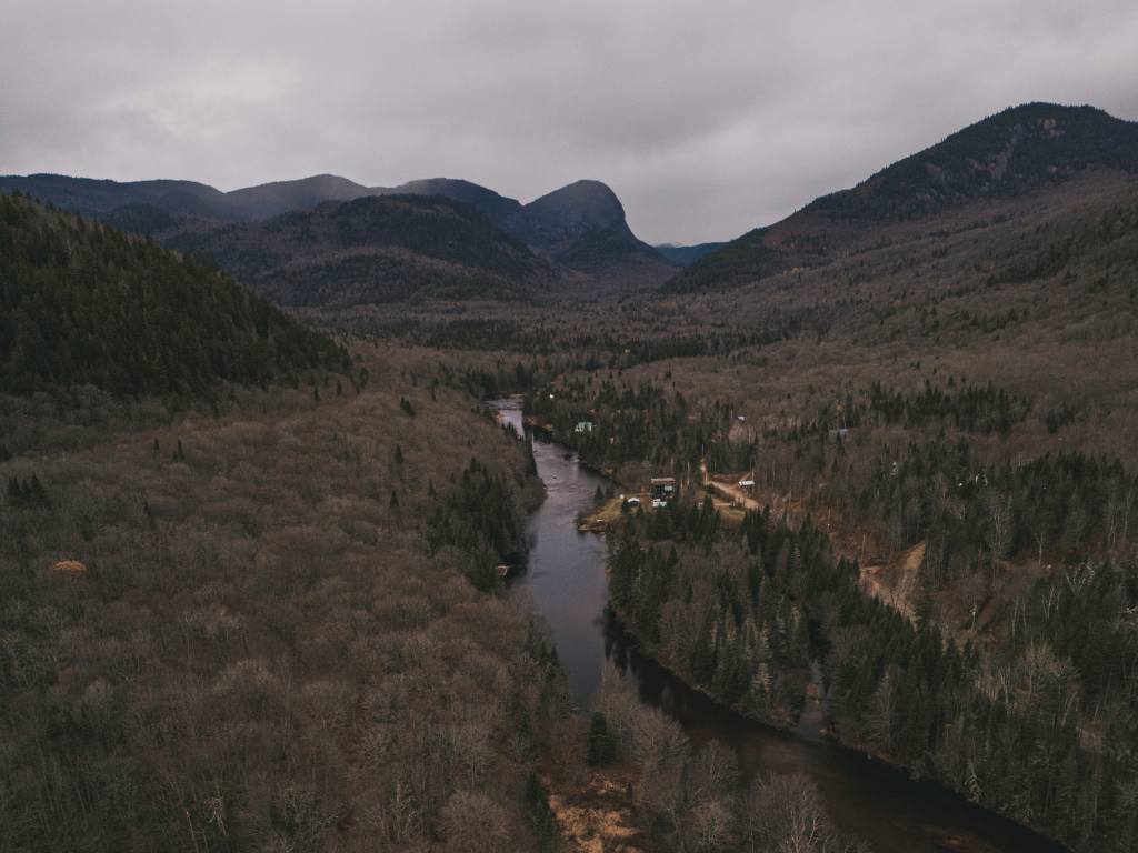 Vue aérienne de la rivière Bras-du-Nord serpentant entre les montagnes et les forêts de la Vallée Bras-du-Nord, à Saint-Raymond, au Québec, en automne.